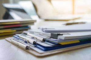 Documents on clipboards sit on desk.