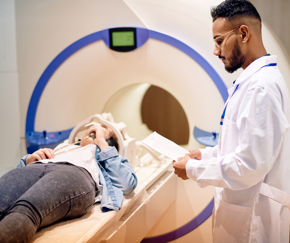 doctor standing by patient entering machine for exam