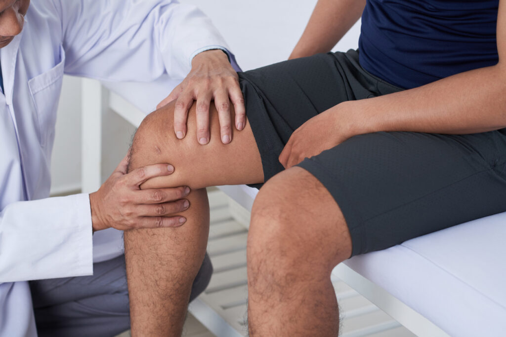 Physical therapist examining patient's knee for personal injury case